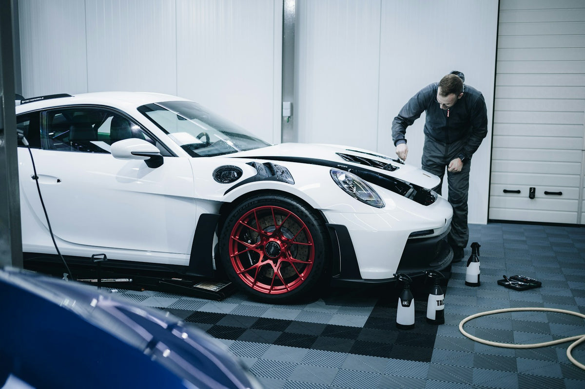 Detailing a white sports car in a garage